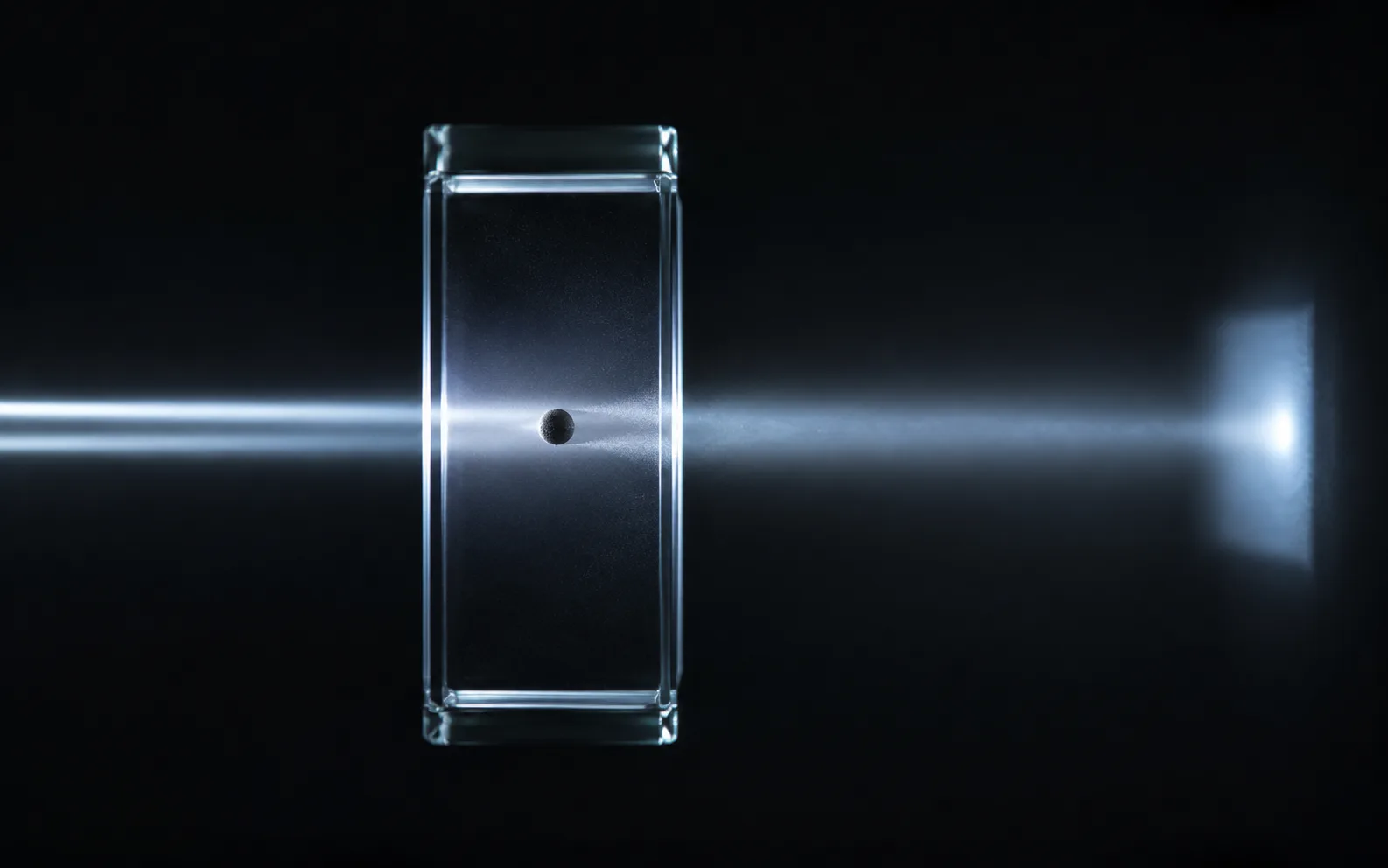 Haz de luz atravesando una celda óptica con una partícula bloqueando parte de la luz hacia el detector